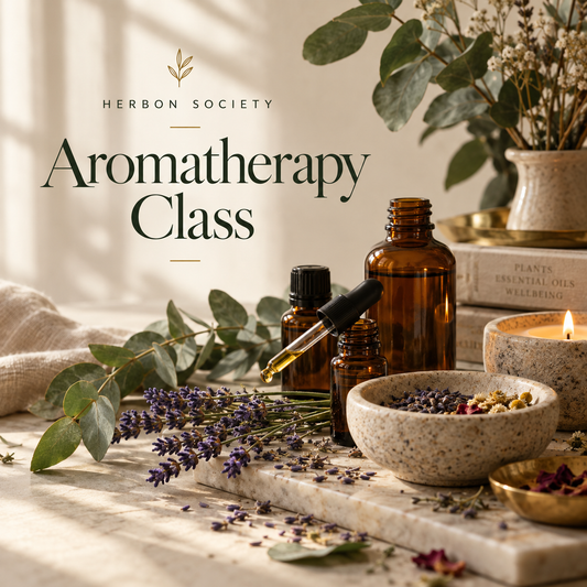 Amber essential oil bottles with lavender, eucalyptus, rosemary, and botanical ingredients arranged for an aromatherapy blending workshop.

